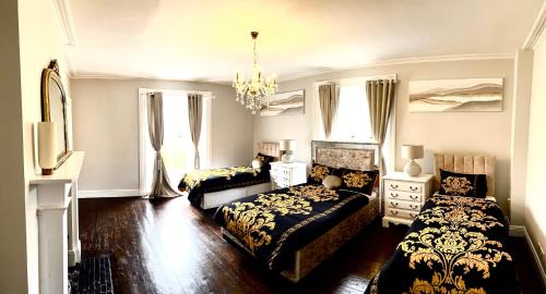 1 dormitorio con 2 camas y lámpara de araña en Skryne Castle en Ross Cross Roads