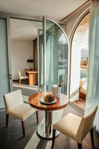 a dining room with a table and two chairs and a room at Avala Resort & Villas in Budva