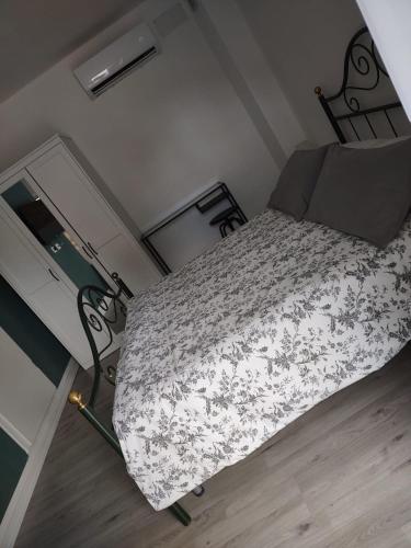 a small bedroom with a bed with a floral bedspread at Affittacamere Scenario in Fogliano Redipúglia