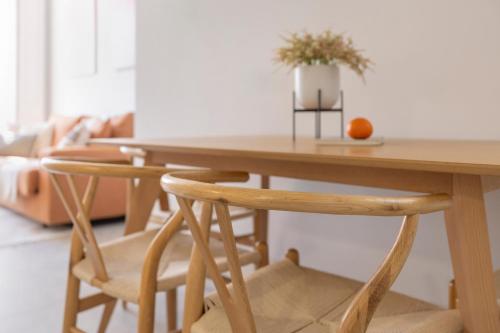 a wooden table with two chairs and an orange on it at Candelaria10 in Cádiz