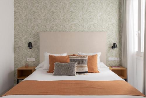 a bedroom with a large bed with orange pillows at Candelaria10 in Cádiz