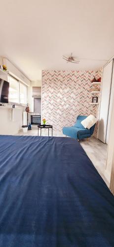 - une chambre avec un lit bleu et un mur dans l'établissement Studio & Expansive Terrace: Urban Oasis in Paris!, à Courbevoie