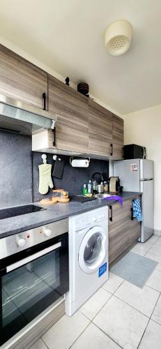 une cuisine avec une machine à laver et un lave-linge dans l'établissement Studio & Expansive Terrace: Urban Oasis in Paris!, à Courbevoie