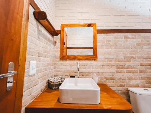 uma casa de banho com um lavatório branco e um espelho. em Toca em Petrópolis