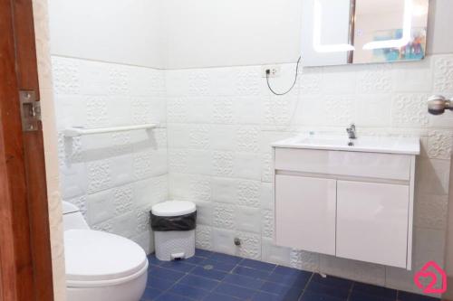 a white bathroom with a toilet and a sink at Departamento con vista en San Borja in Lima