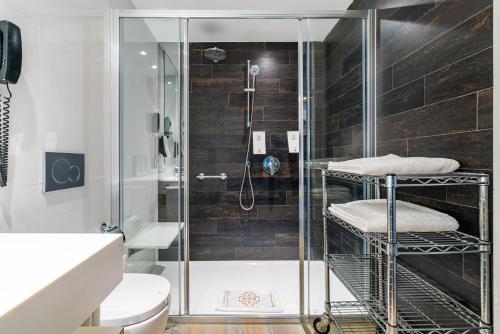 um chuveiro com uma porta de vidro na casa de banho em Adrián Hoteles Colón Guanahaní Adultos Only em Adeje