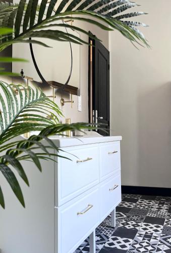 a bathroom with a white dresser and a mirror at Le Clos Gabrielle in Châtellerault