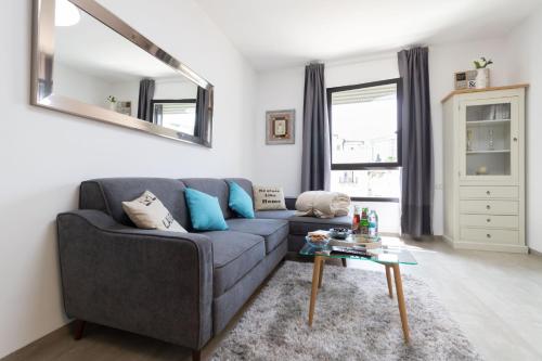 a living room with a gray couch and a table at King David Apartment - J&J in Jerusalem
