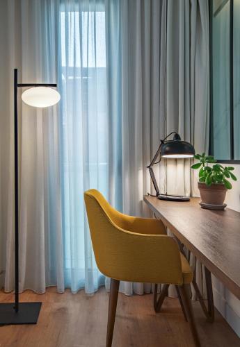 a dining room table with a yellow chair and a lamp at The Residence Christokopidou Hotel & Spa in Athens