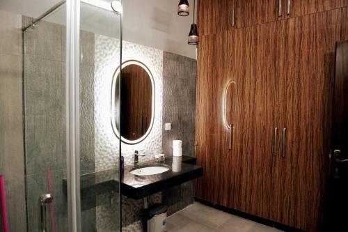 La salle de bains est pourvue d'un lavabo et d'une douche en verre. dans l'établissement Centrally located Villa in the middle of Lahore, à Lahore