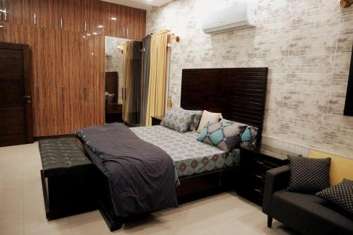 a bedroom with a bed and a chair at Centrally located Villa in the middle of Lahore in Lahore