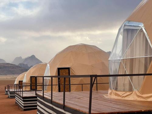 una fila de tiendas domeadas en el desierto en Hasan Zawaideh Camp en Wadi Rum