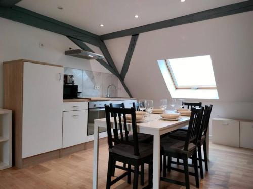 une salle à manger avec une table et des chaises et une cuisine dans l'établissement Le Charme du Bois-25min Strasbourg centre-WiFi-TV, à Wasselonne