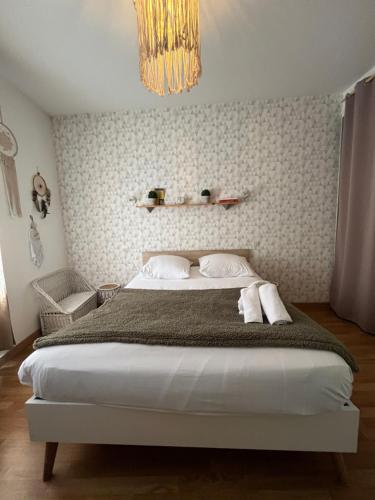 - une chambre avec un grand lit et un lustre dans l'établissement Le grand abri de la Garenne - Séjour cosy à Blois, à Blois