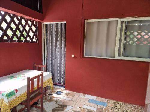 a red room with a bed and two windows at Bungalow chez Mouch Nosy-Be 3 in Nosy Be