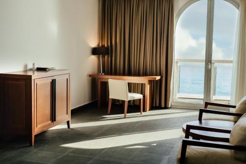 a room with a desk and a chair in front of a window at Avala Resort & Villas in Budva