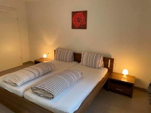 a bed with two pillows and a red rose on the wall at Ferienwohnung Schweizer Sennenhund in Nauders