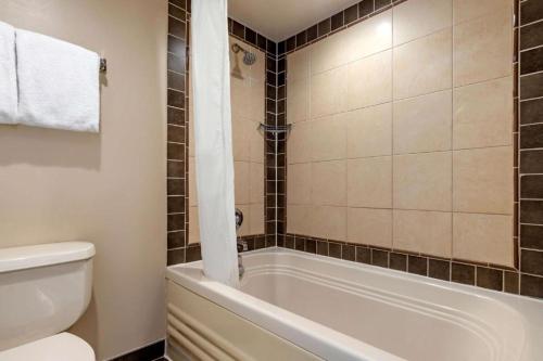 La salle de bains est pourvue d'une baignoire blanche et de toilettes. dans l'établissement Hilton Vacation ocean beach club Virginia Beach, à Virginia Beach