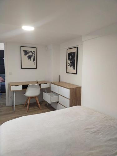 une chambre avec un lit, un bureau et une chaise dans l'établissement 2 pièce avec terrasse ensoleillé, à Suresnes
