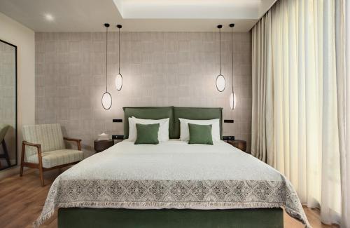a bedroom with a large bed and a chair at The Residence Christokopidou Hotel & Spa in Athens