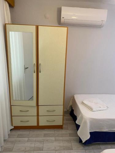 a bedroom with a dresser with a mirror and a bed at İZAN VİLLA BAKIŞ APARTMENTS in Bodrum City