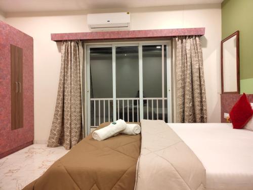 a bedroom with a large bed and a window at Woodland farm vila in Mahabaleshwar