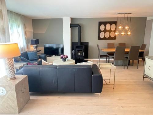 a living room with a blue couch and a dining room at Walensee House & Apartments in Unterterzen