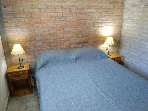 a bedroom with a bed and two lamps on tables at Bungalows Tiempo Libre in Colón