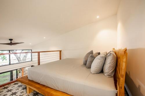 sypialnia z dużym łóżkiem z poduszkami w obiekcie Tiny Homes Venao Cove w mieście Playa Venao