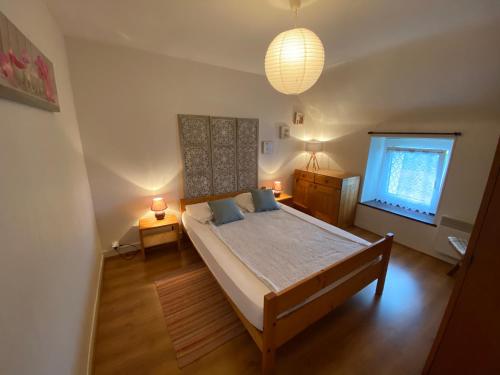 um quarto com uma cama grande e uma janela em RÉF 302 - LARMOR-PLAGE longère 3 pièces avec terrasse et jardin proche mer et commodités em Larmor-Plage