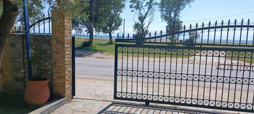 ein eisernes Tor mit einer Bank vor einem Strand in der Unterkunft Filoxenia in Nea Iraklia