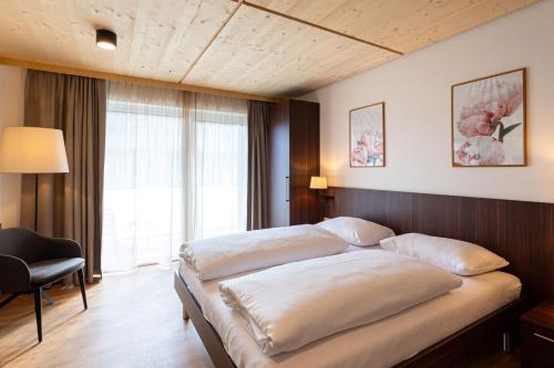 a bedroom with a large bed and a large window at eduCARE Hotel in Treffen