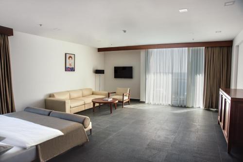a hotel room with a bed and a couch at Avala Resort & Villas in Budva