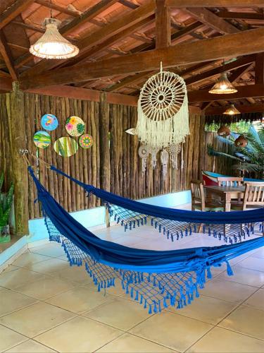a hammock in a room with a wooden wall at Pousada Banana Verde in Ilhabela