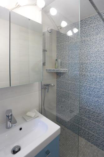 une salle de bain avec un lavabo et une douche en verre dans l'établissement Studio le cocon, à La Grande Motte