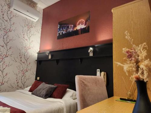 a hotel room with a bed and a table and a wall at Hôtel Abalone - Centre Gare in Nîmes