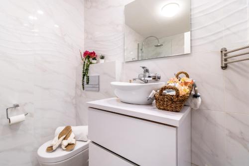 a white bathroom with a sink and a toilet at King David Apartment - J&J in Jerusalem