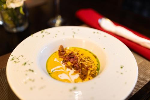 a white plate with a bowl of food on a table at Hotel Cubitá Boutique Resort & Spa in Chitré