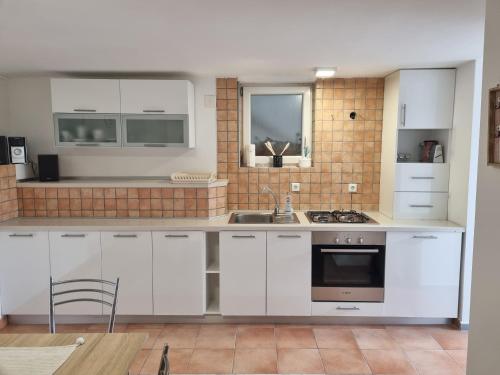 a kitchen with white cabinets and a sink at Sanda in Novi Vinodolski