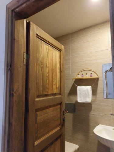 a bathroom with a wooden door and a sink at Grand Uchisar Hotel in Uchisar