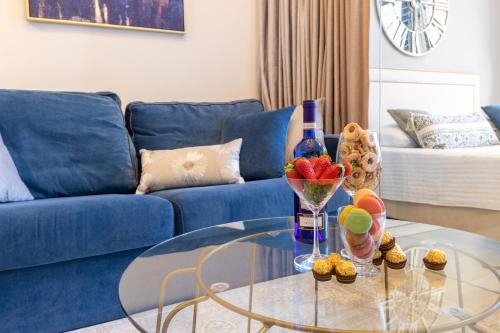 a living room with a blue couch and a glass table at King David Apartment - J&J in Jerusalem