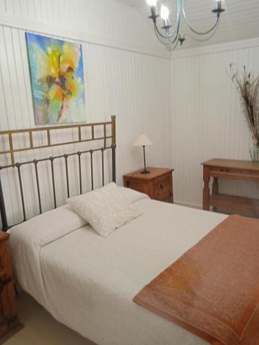 - une chambre avec un lit, une table et un tableau dans l'établissement Apartamentos LA CASONA, à Jaraiz de la Vera