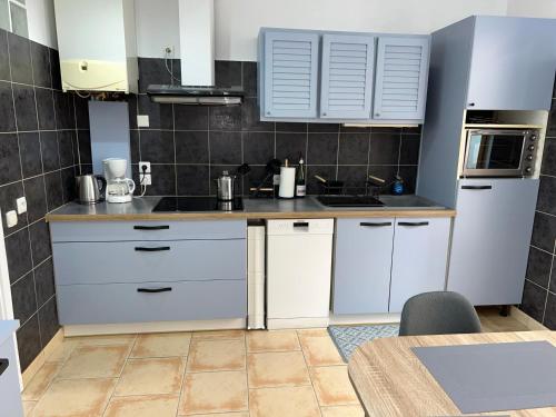 une cuisine avec des armoires blanches et un comptoir dans l'établissement Maison Rouget De L’Isle, à Béziers