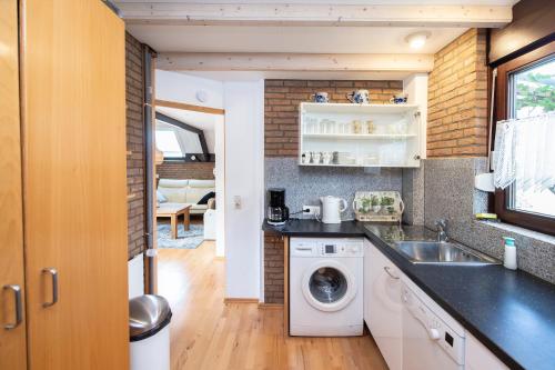 cocina con fregadero y lavadora en Luxe 4p huis met SAUNA bij Grevelingenmeer!, en Herkingen