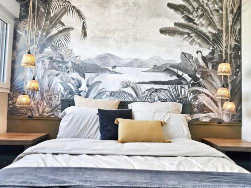 - une chambre avec un grand lit et du papier peint tropical dans l'établissement T2 design proche gare/Intra-M/Sillon, garage privé, à Saint-Malo