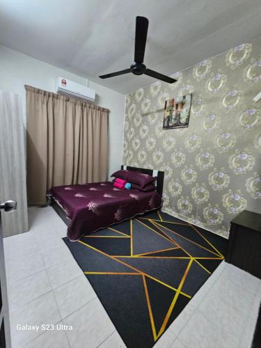 una camera con letto viola e ventilatore a soffitto di Maisarah Homestay Melaka, Islamic Home in Melaka a Malacca