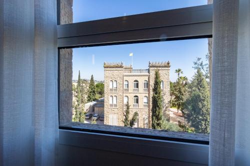 a view of a building through a window at King David Apartment - J&J in Jerusalem