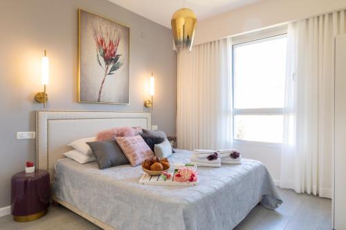a bedroom with a bed with a tray of food on it at King David Apartment - J&J in Jerusalem