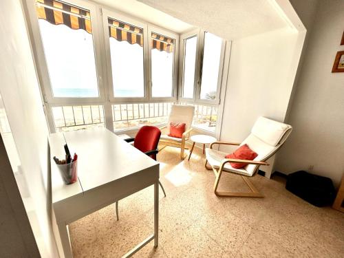 Habitación con escritorio, sillas y ventanas. en Piso en el Puig: Frente al Mar, en El Puig