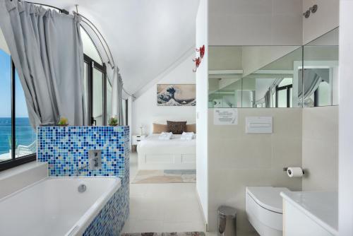 a bathroom with a tub and a toilet and a sink at RentitSpain Casa Acantilado in Granada
